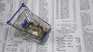 money in shopping cart with reciepts